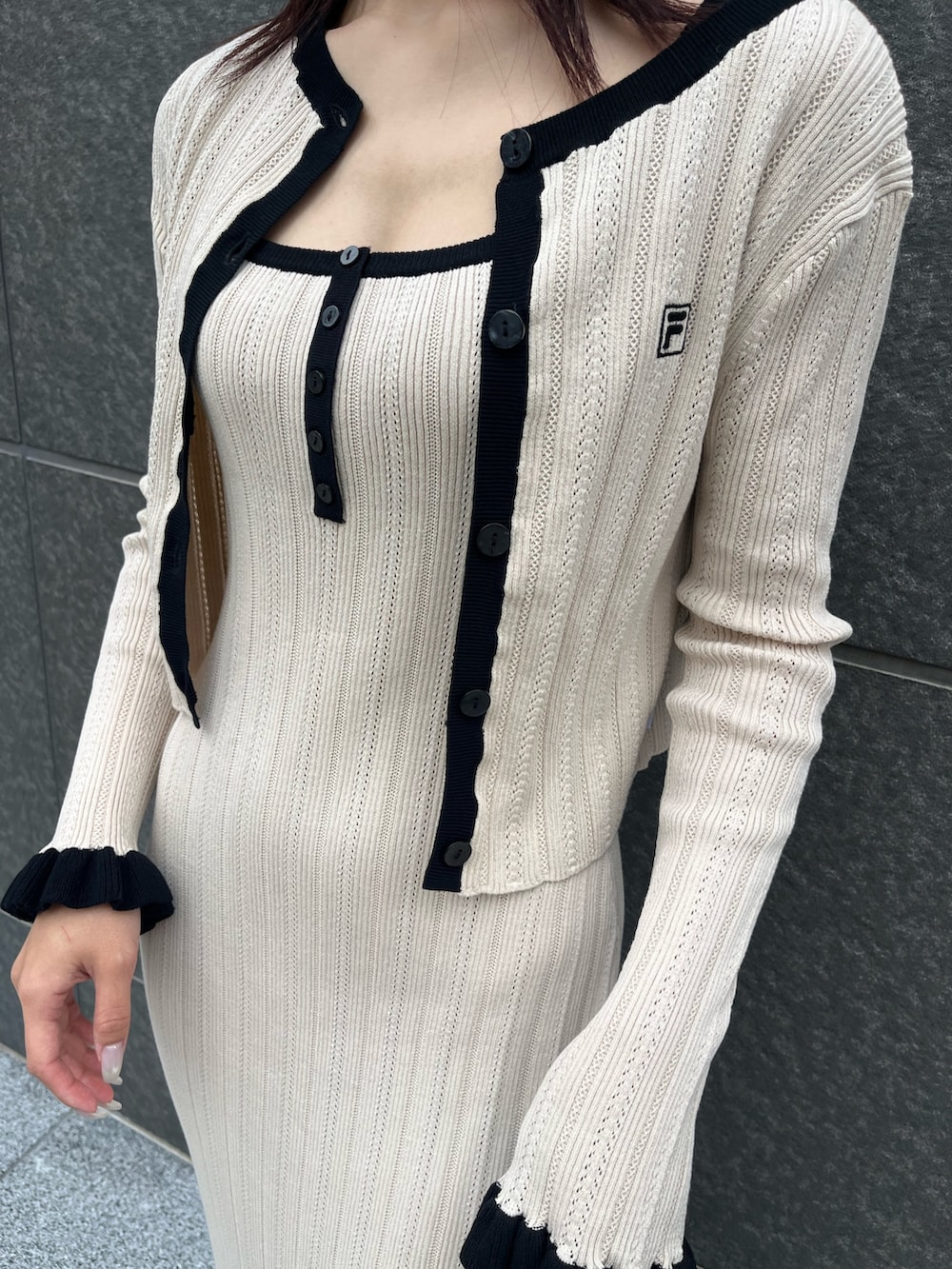 ブラウン系のハンドバッグ、ベージュ系のワンピース、ベージュ系のカーディガン/ボレロを着用したレディースの冬コーディネートの6枚目の写真