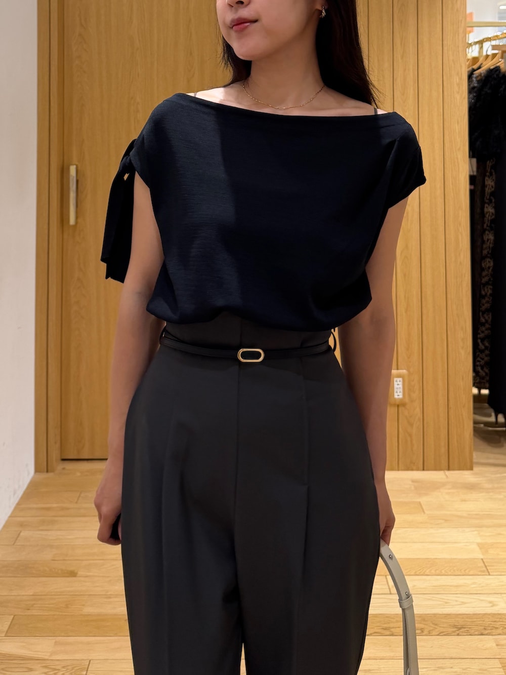 グレー系のその他パンツ、ブラック系のニット/セーター、ホワイト系のハンドバッグを着用したレディースの夏コーディネートの4枚目の写真