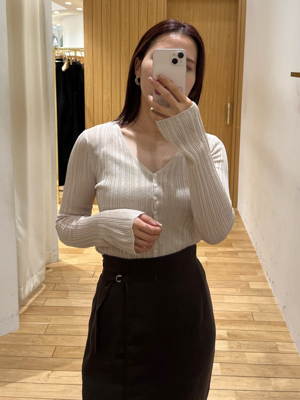 ブラウン系のスカート、ホワイト系のTシャツ/カットソー、ホワイト系のサンダルを着用したレディースの春コーディネートの5枚目の写真