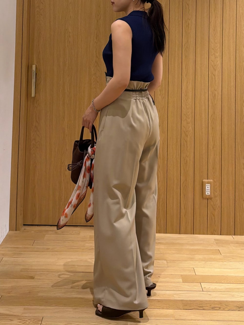 ベージュ系のその他パンツ、ブルー系のニット/セーター、ブラウン系のサンダルを着用したレディースの夏コーディネートの2枚目の写真