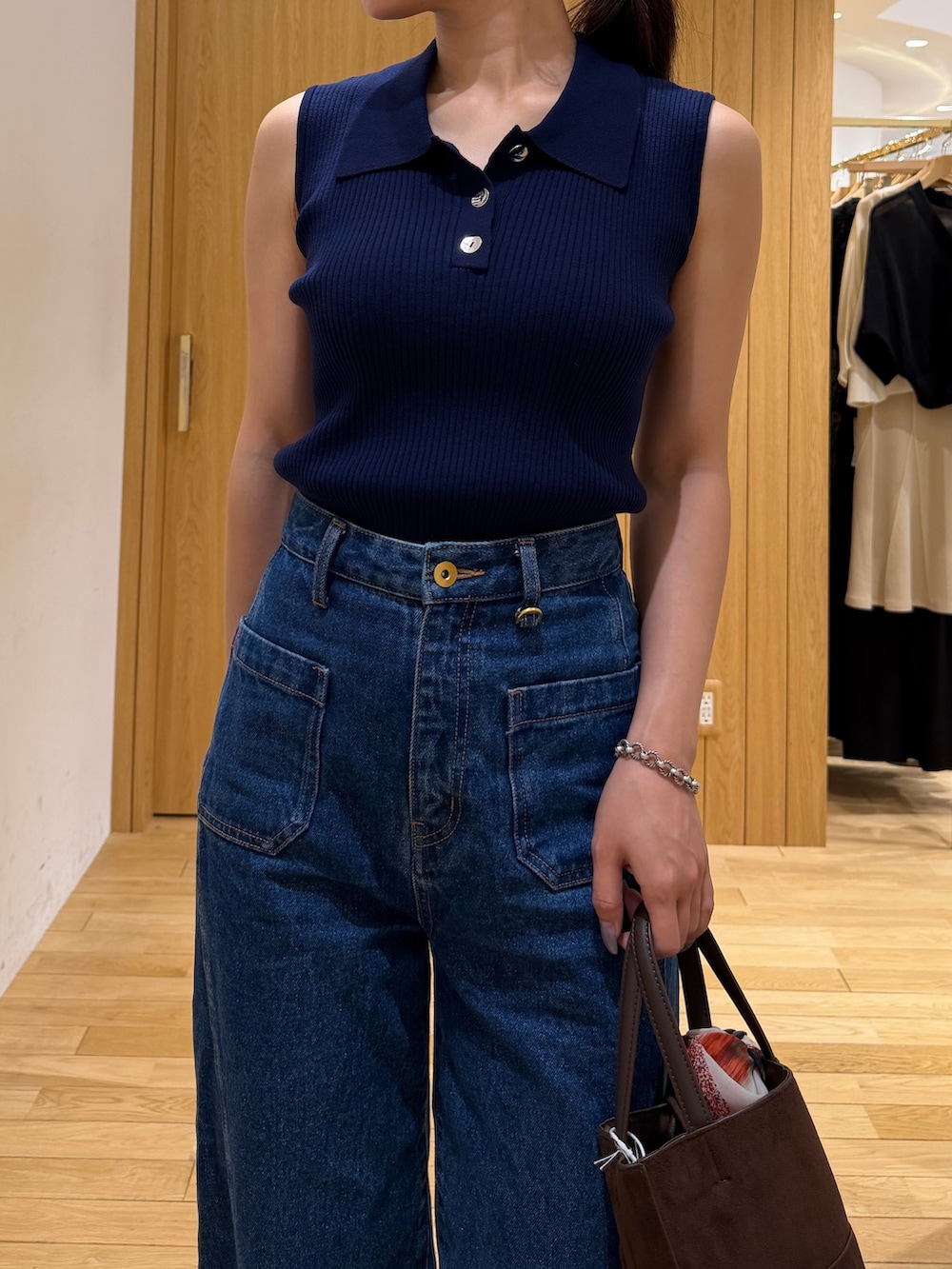ブルー系のデニムパンツ、ブルー系のニット/セーター、ブラウン系のサンダルを着用したレディースの夏コーディネートの4枚目の写真