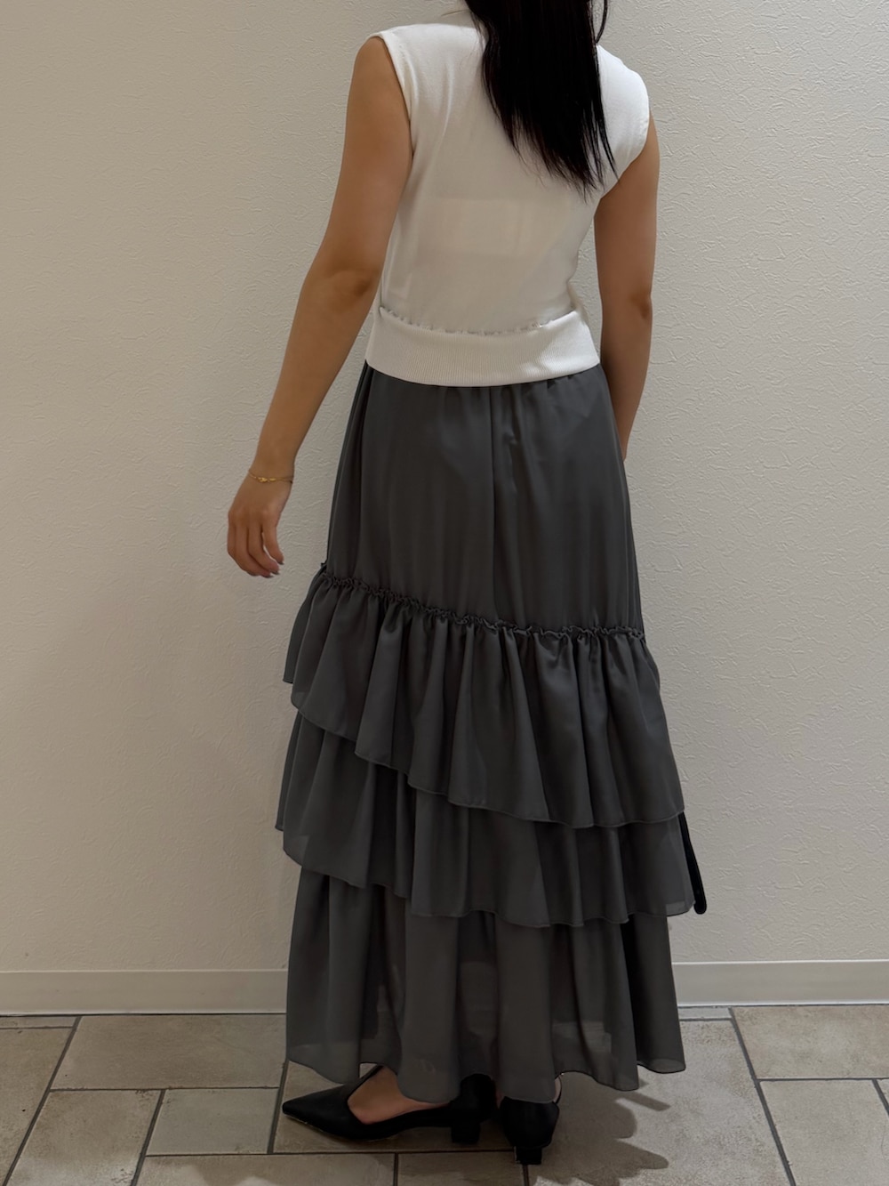 ホワイト系のワンピース、ブラック系のハンドバッグ、ブラック系のパンプスを着用したレディースの夏コーディネートの3枚目の写真