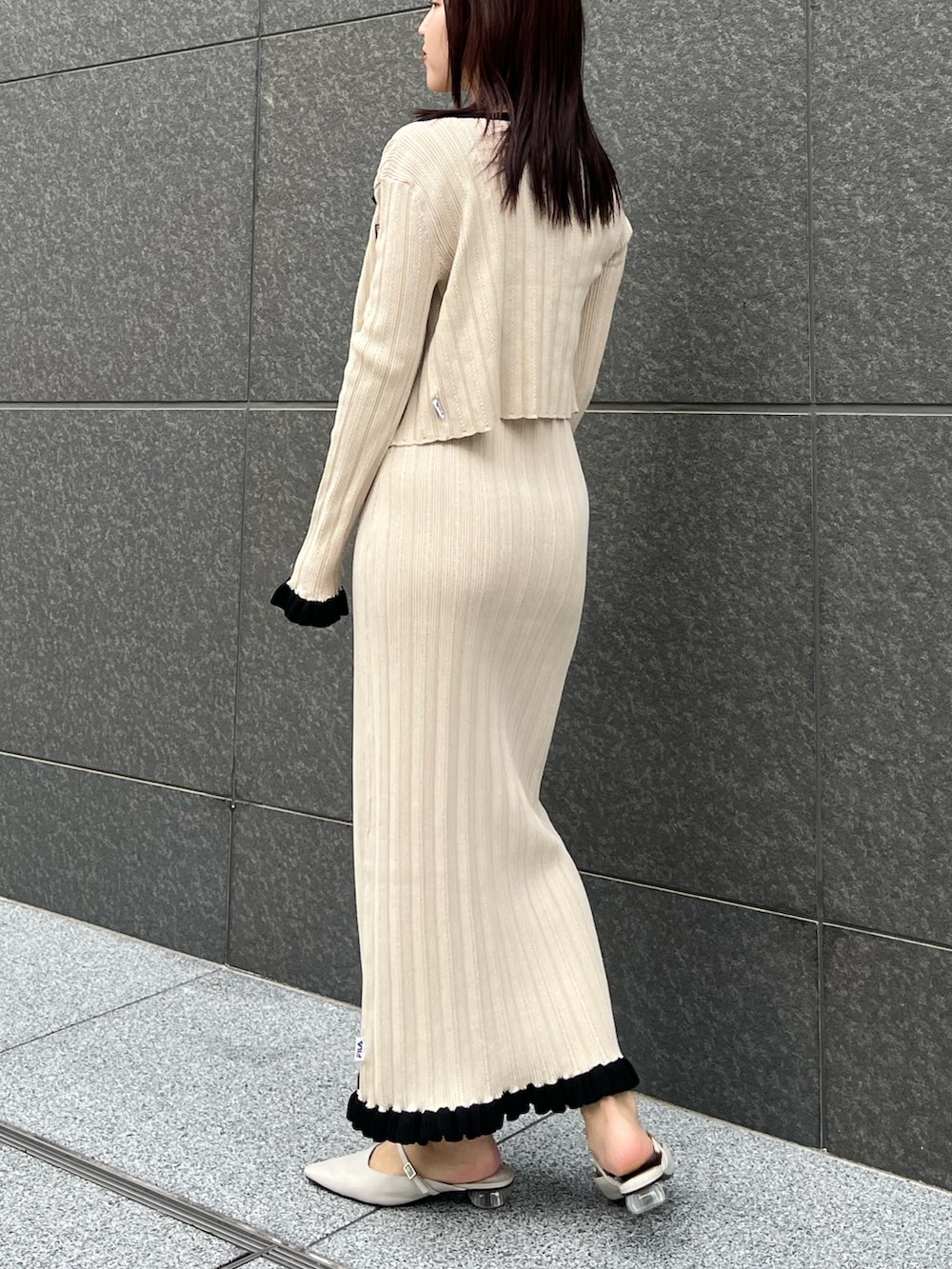 ブラウン系のハンドバッグ、ベージュ系のワンピース、ベージュ系のカーディガン/ボレロを着用したレディースの冬コーディネートの3枚目の写真