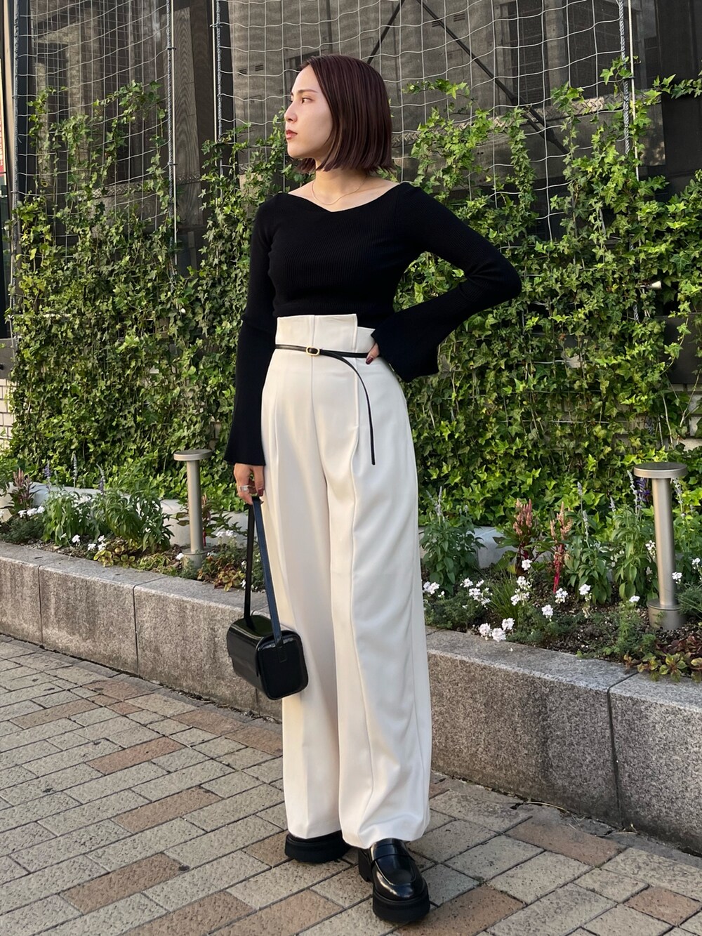 ブラック系のニット/セーター、ホワイト系のその他パンツ、ブラック系のローファーを着用したレディースの秋コーディネートの3枚目の写真