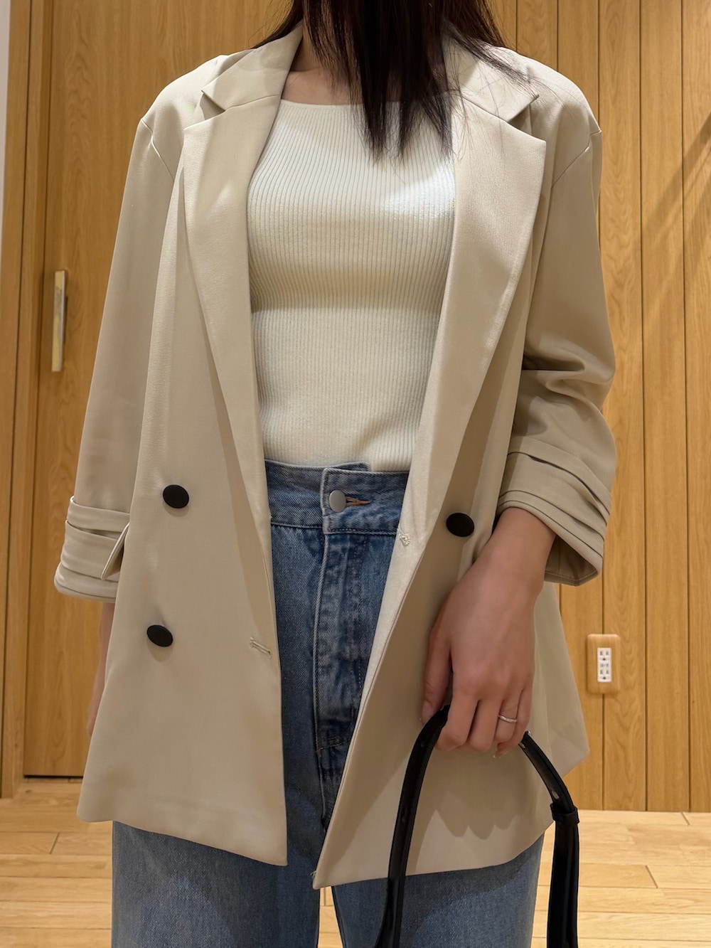 ブルー系のデニムパンツ、ホワイト系のタンクトップ、ベージュ系のテーラードジャケットを着用したレディースの春コーディネートの4枚目の写真