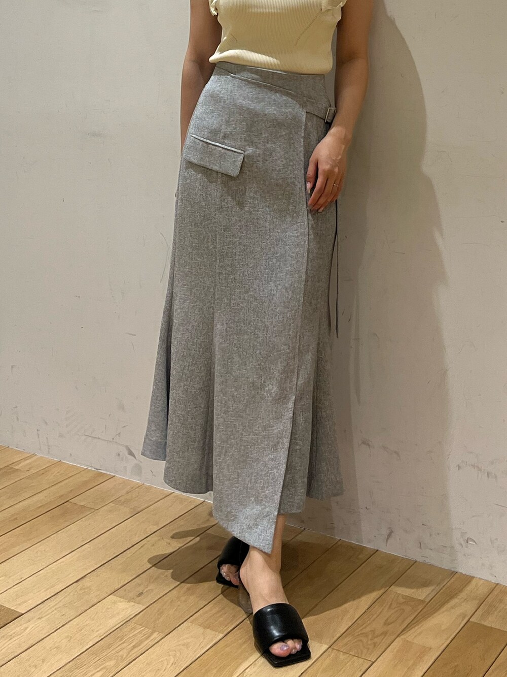 ホワイト系のニット/セーター、グレー系のスカート、ブラック系のサンダルを着用したレディースの夏コーディネートの4枚目の写真