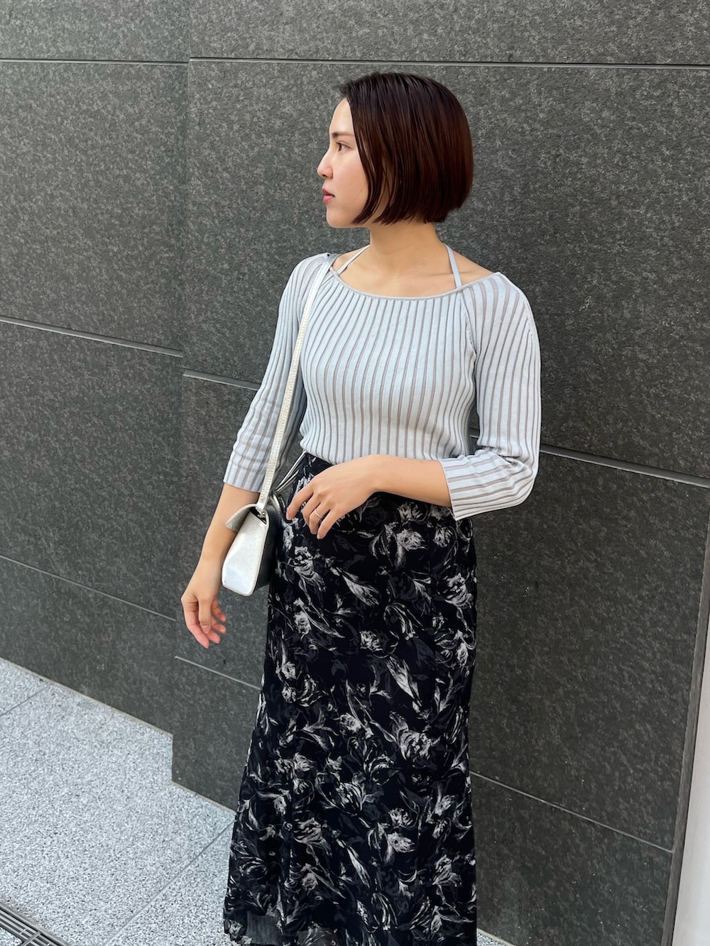 ブラック系のスカート、シルバー系のパンプス、ブルー系のニット/セーターを着用したレディースの春コーディネートの4枚目の写真