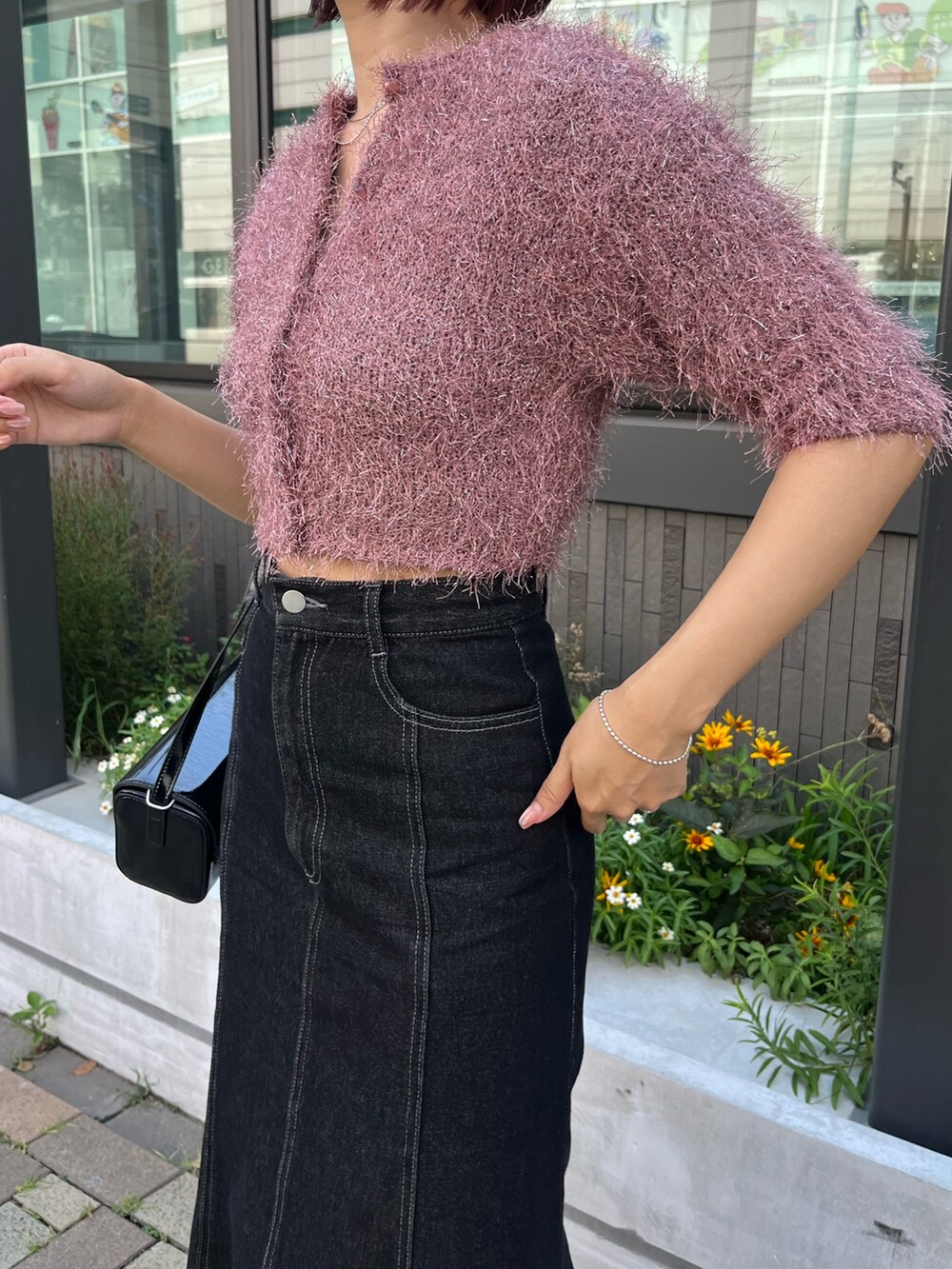 ブラック系のデニムスカート、ピンク系のカーディガン/ボレロ、ブラック系のショルダーバッグを着用したレディースの秋コーディネートの3枚目の写真