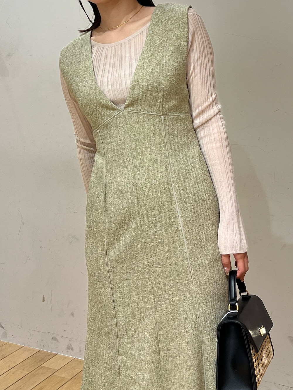 ホワイト系のTシャツ/カットソー、グリーン系のジャンパースカート、ホワイト系のサンダルを着用したレディースの春コーディネートの4枚目の写真