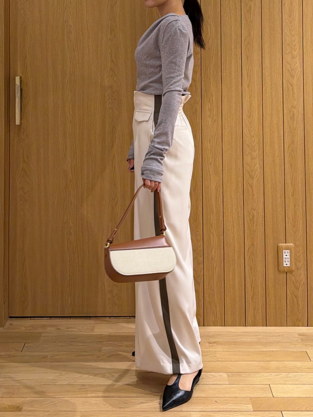ホワイト系のその他パンツ、グレー系のTシャツ/カットソー、ブラウン系のハンドバッグを着用したレディースの冬コーディネートの2枚目の写真