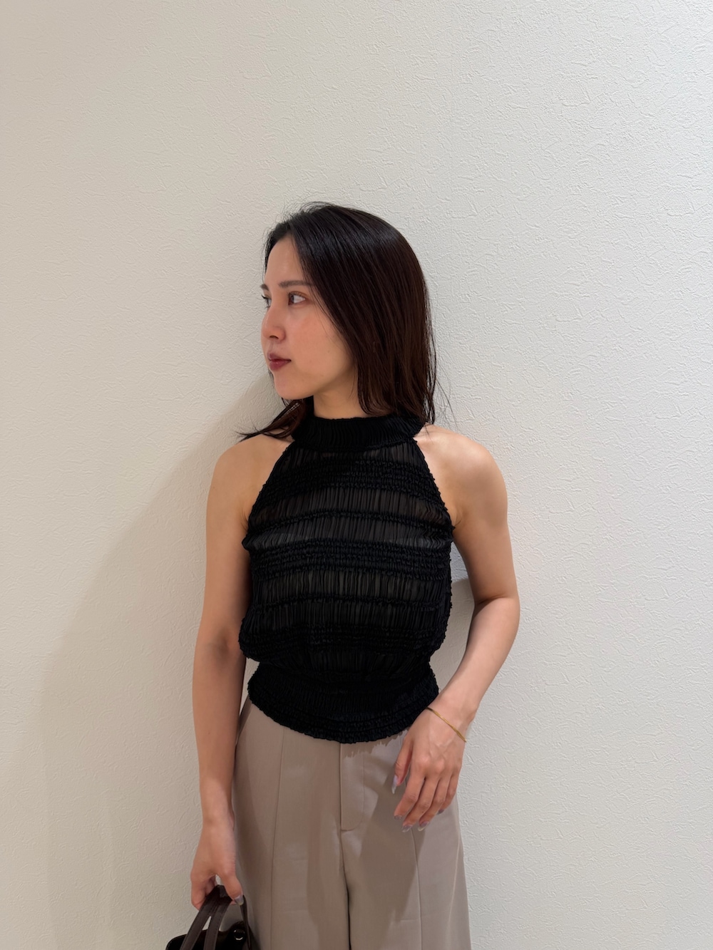 ブラウン系のハンドバッグ、ベージュ系のその他パンツ、ブラック系のシャツ/ブラウスを着用したレディースの夏コーディネートの4枚目の写真
