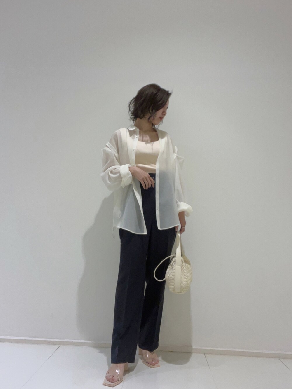 ホワイト系のハンドバッグ、その他のサンダル、ホワイト系のニット/セーターを着用したレディースの春コーディネートの3枚目の写真