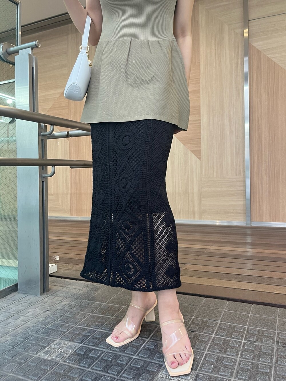 ベージュ系のニット/セーター、ブラック系のスカート、その他のサンダルを着用したレディースの夏コーディネートの4枚目の写真