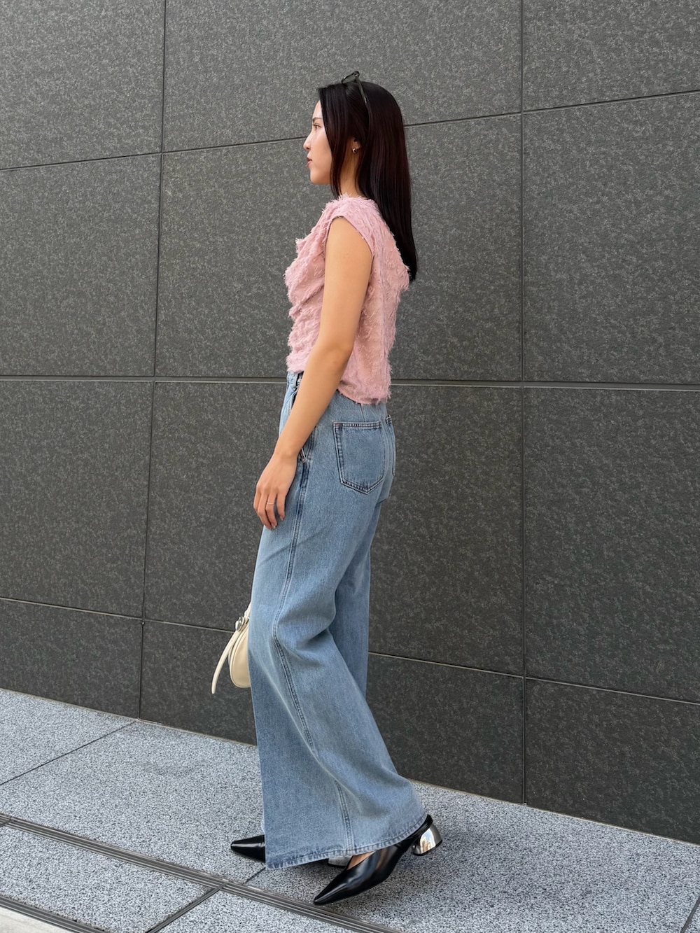 ピンク系のシャツ/ブラウス、ブルー系のデニムパンツ、ブラック系のパンプスを着用したレディースの春コーディネートの2枚目の写真