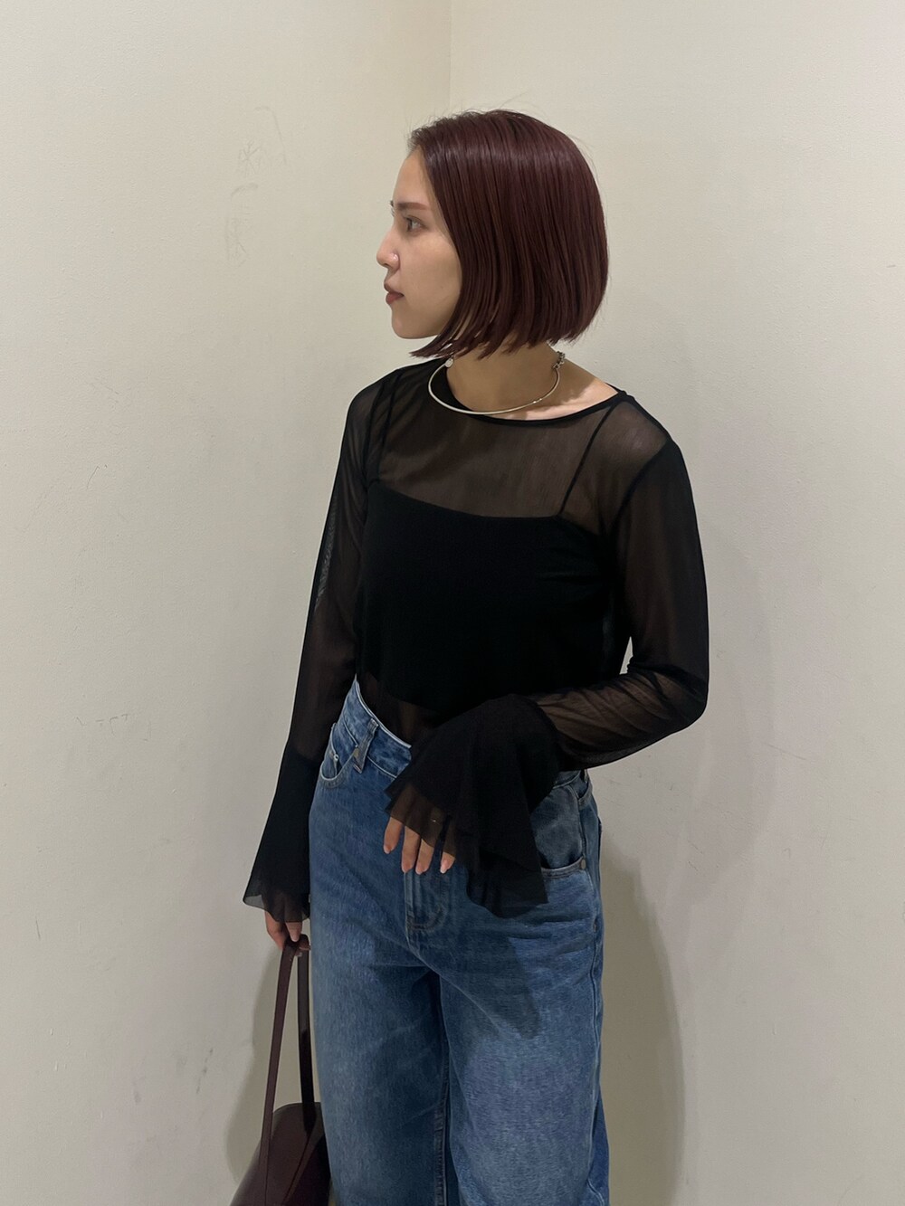 ブルー系のデニムパンツ、レッド系のショルダーバッグ、ブラック系のブーツを着用したレディースの秋コーディネートの7枚目の写真