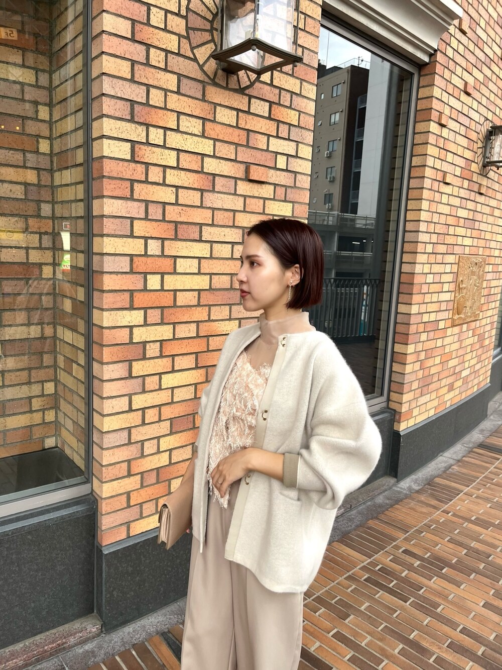 ホワイト系のカーディガン/ボレロ、ベージュ系のパンツドレス、ブラウン系のパンプスを着用したレディースの秋コーディネートの4枚目の写真