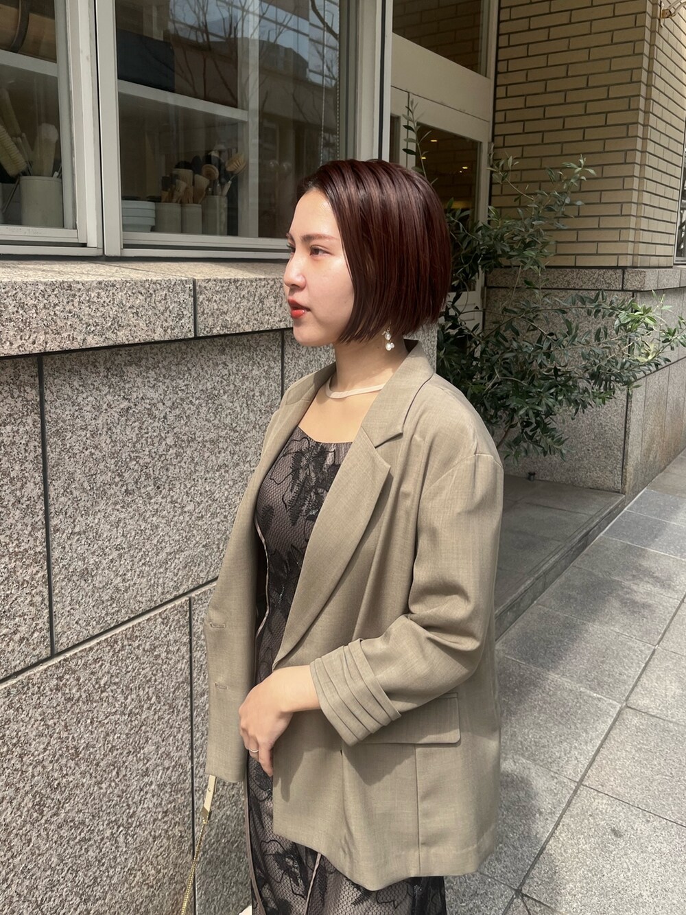 ベージュ系のパンプス、ブラウン系のテーラードジャケット、ブラック系のドレスを着用したレディースの春コーディネートの4枚目の写真