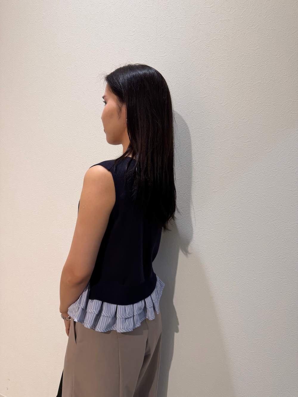 ベージュ系のその他パンツ、ブルー系のニット/セーター、ブラック系のハンドバッグを着用したレディースの夏コーディネートの5枚目の写真