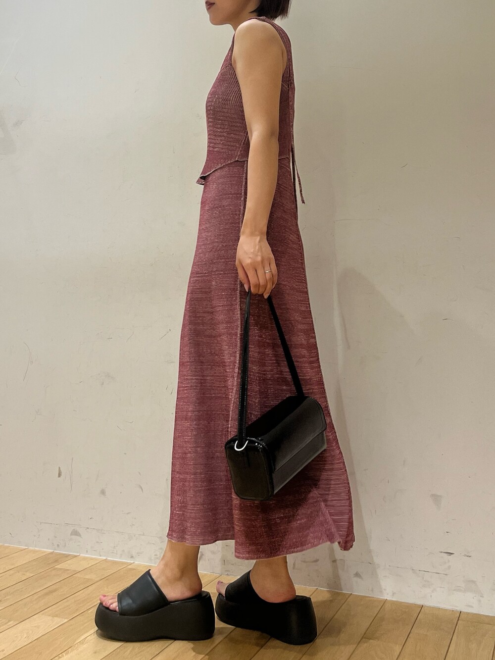 パープル系のワンピース、ブラック系のショルダーバッグ、ブラック系のブーツを着用したレディースの夏コーディネートの5枚目の写真