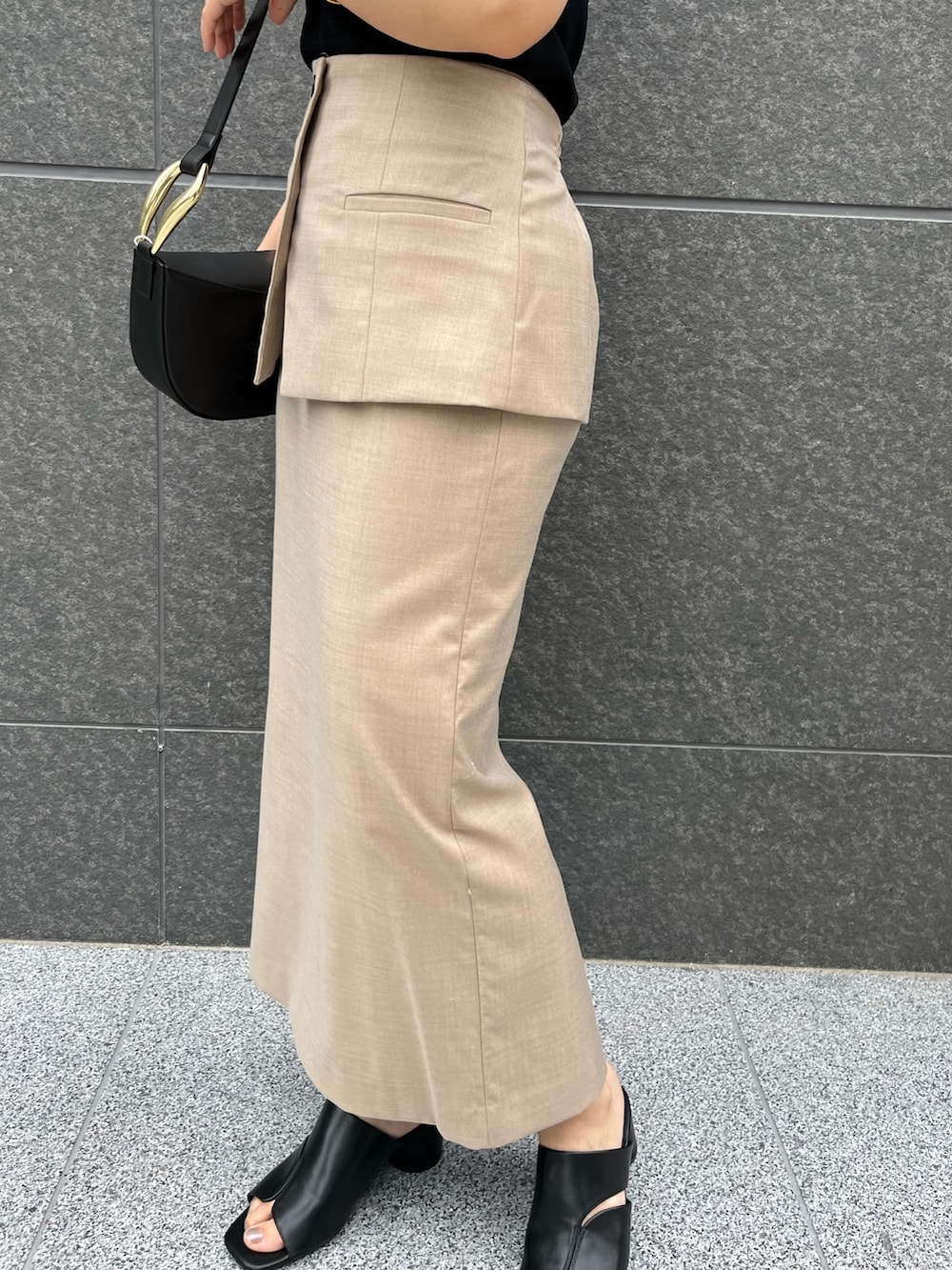 ブラック系のサンダル、ブラック系のニット/セーター、ベージュ系のスカートを着用したレディースの春コーディネートの7枚目の写真