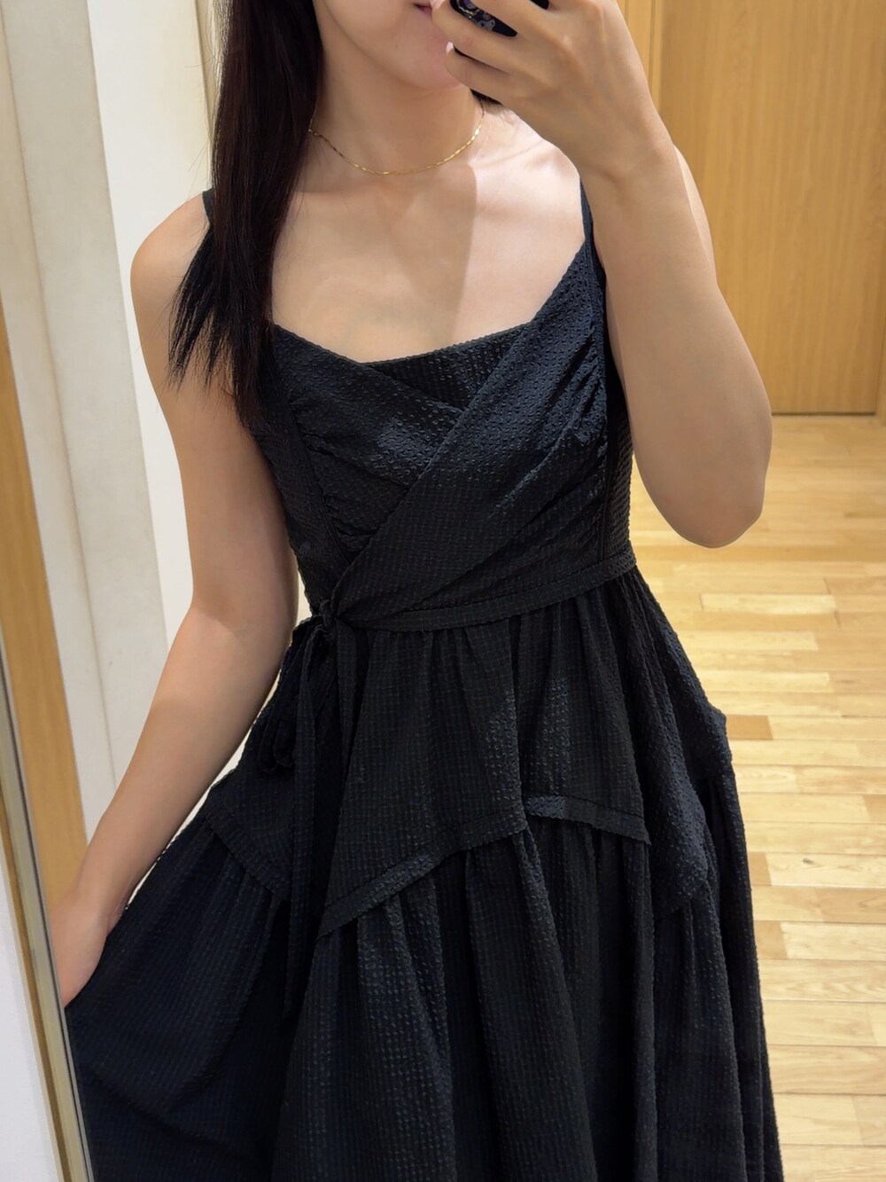 ブラック系のワンピース、ブラック系のハンドバッグ、グリーン系のパンプスを着用したレディースの夏コーディネートの4枚目の写真