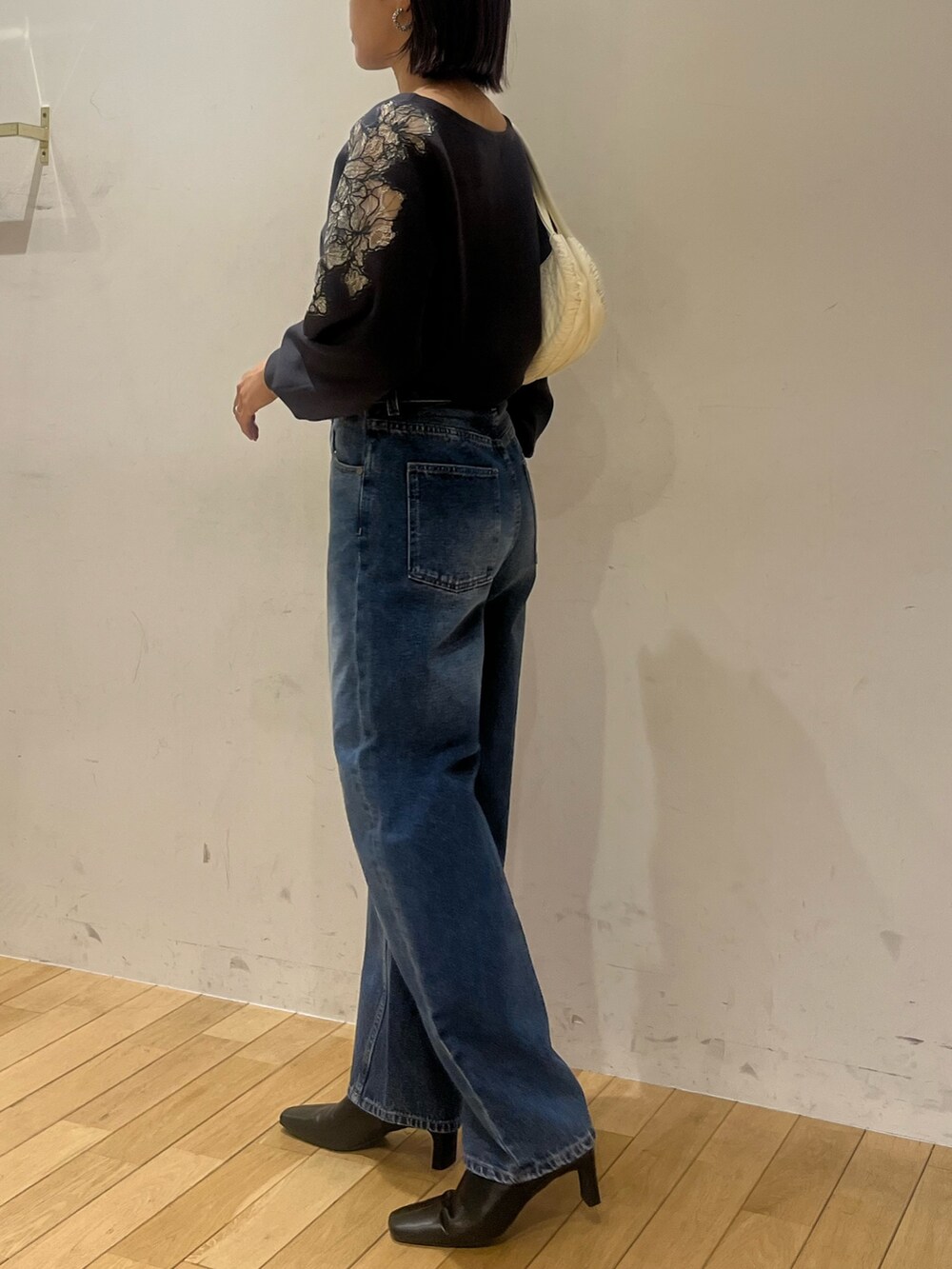 ブラック系のブーツ、ブルー系のデニムパンツ、グレー系のニット/セーターを着用したレディースの秋コーディネートの5枚目の写真