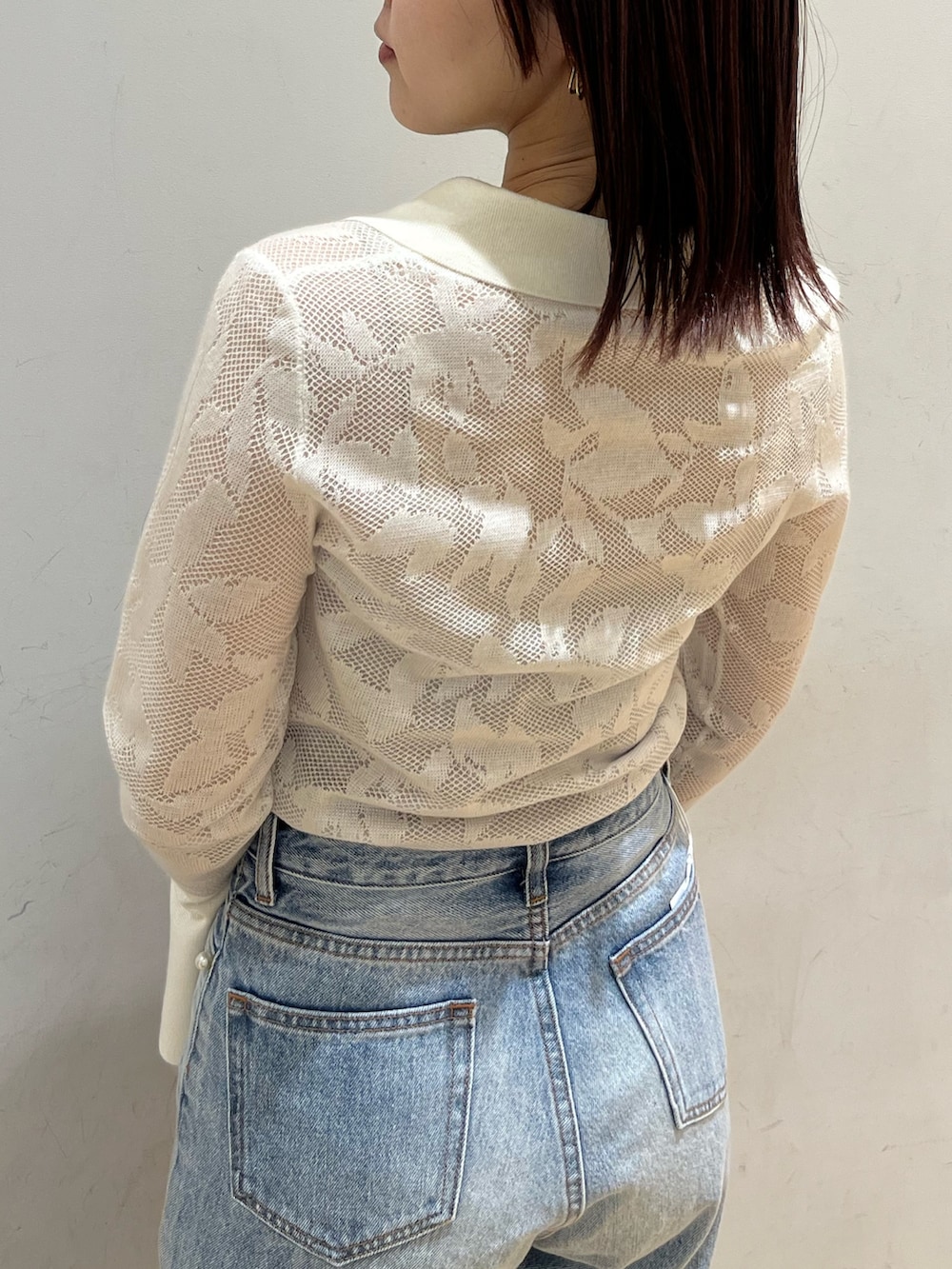 シルバー系のサンダル、ホワイト系のニット/セーター、ブルー系のデニムパンツを着用したレディースの春コーディネートの5枚目の写真