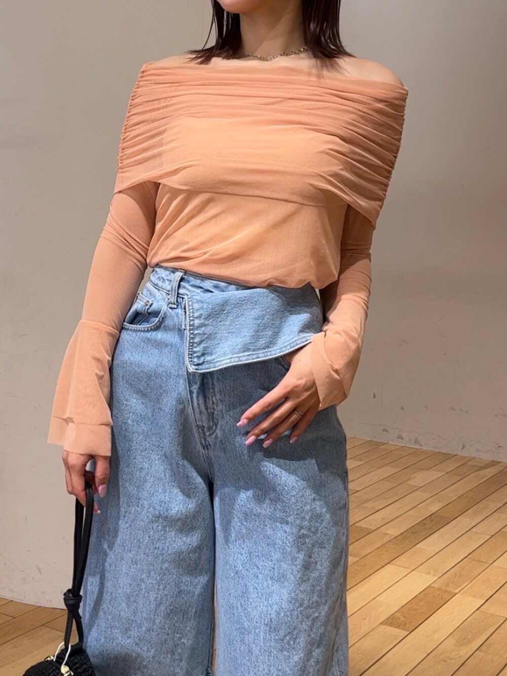 ブラック系のショルダーバッグ、ブラック系のサンダル、ブルー系のデニムパンツを着用したレディースの春コーディネートの4枚目の写真