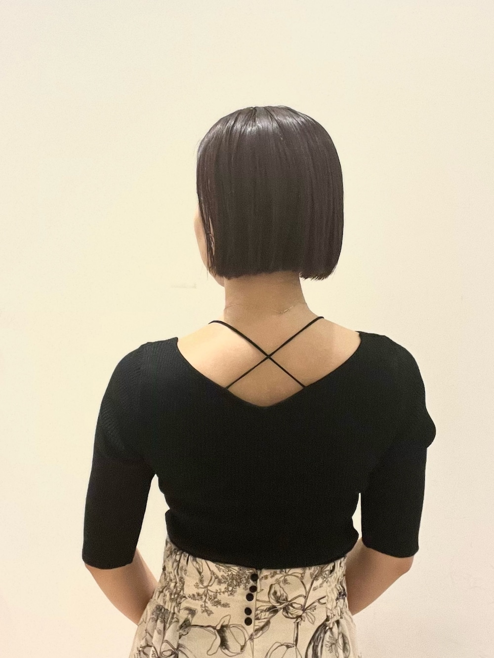 イエロー系のスカート、ブラック系のハンドバッグ、ブラック系のニット/セーターを着用したレディースの秋コーディネートの6枚目の写真