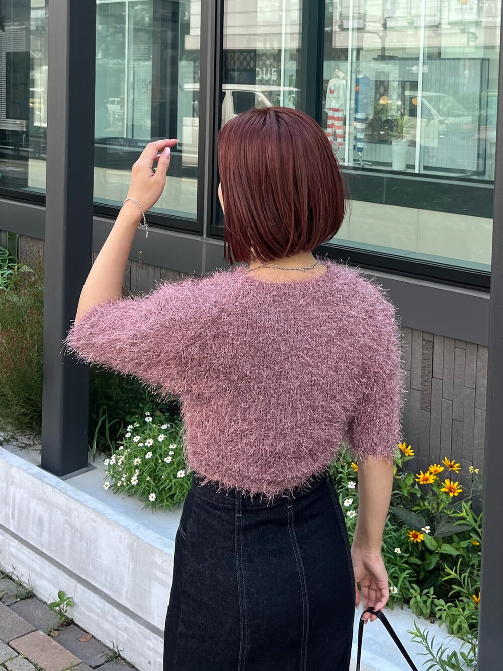 ブラック系のデニムスカート、ピンク系のカーディガン/ボレロ、ブラック系のショルダーバッグを着用したレディースの秋コーディネートの5枚目の写真