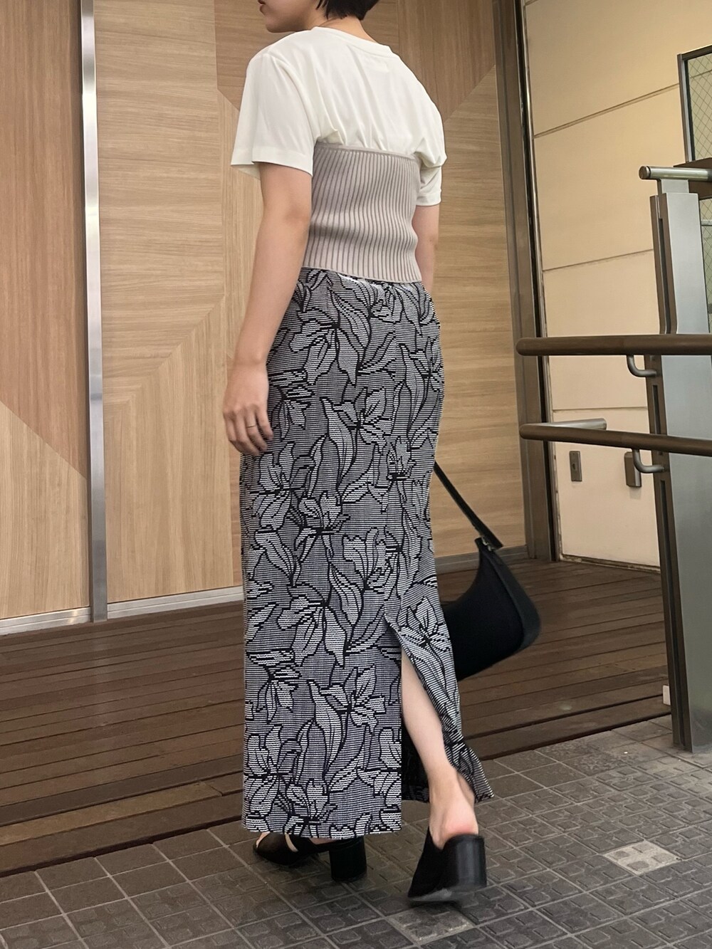 ブラック系のハンドバッグ、ブラック系のサンダル、ブラック系のスカートを着用したレディースの春コーディネートの2枚目の写真