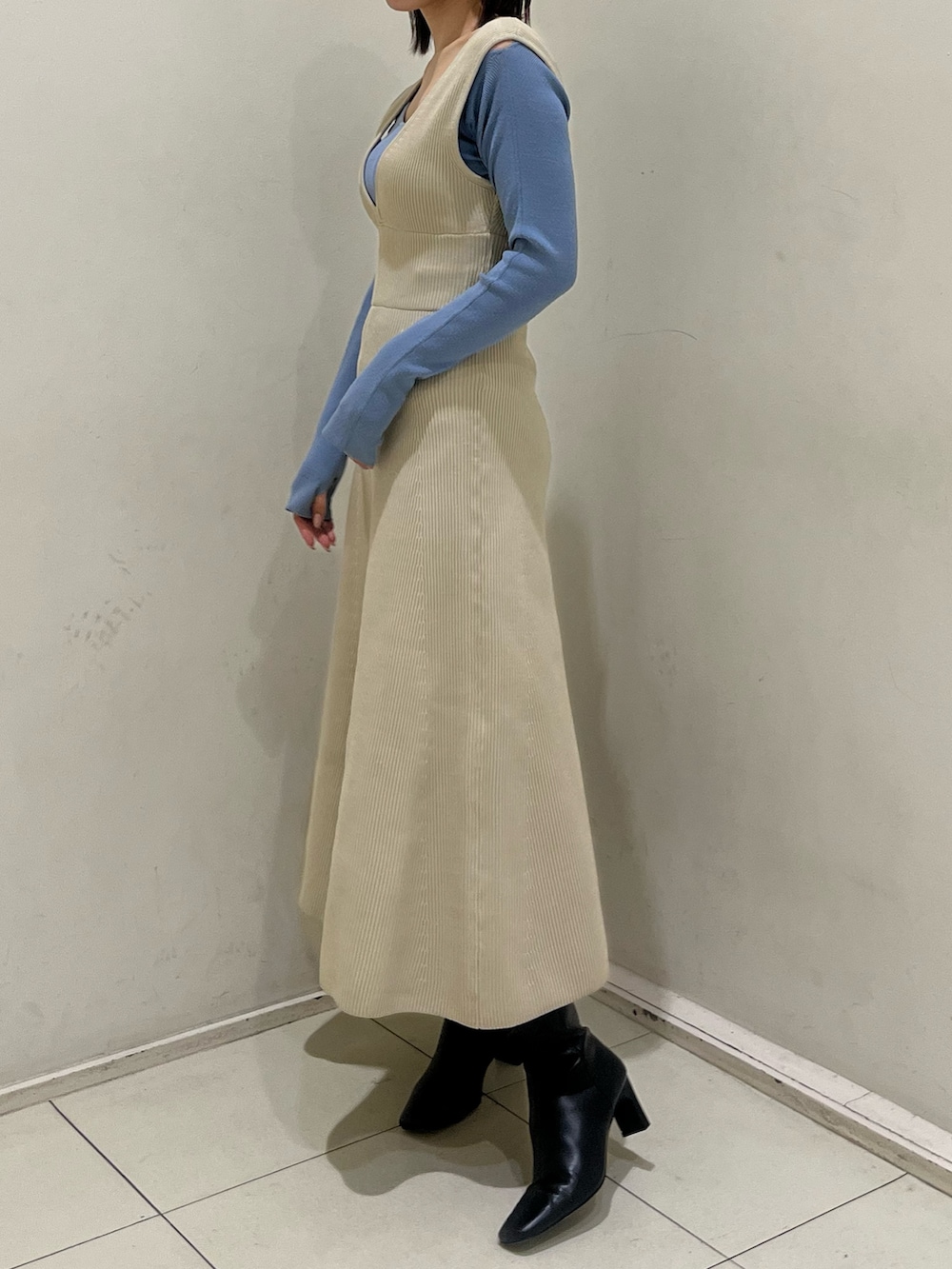 ブラック系のブーツ、ホワイト系のジャンパースカート、ブルー系のニット/セーターを着用したレディースの冬コーディネートの2枚目の写真