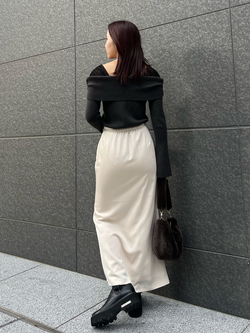 ホワイト系のスカート、ブラウン系のショルダーバッグ、ブラック系のニット/セーターを着用したレディースの冬コーディネートの3枚目の写真