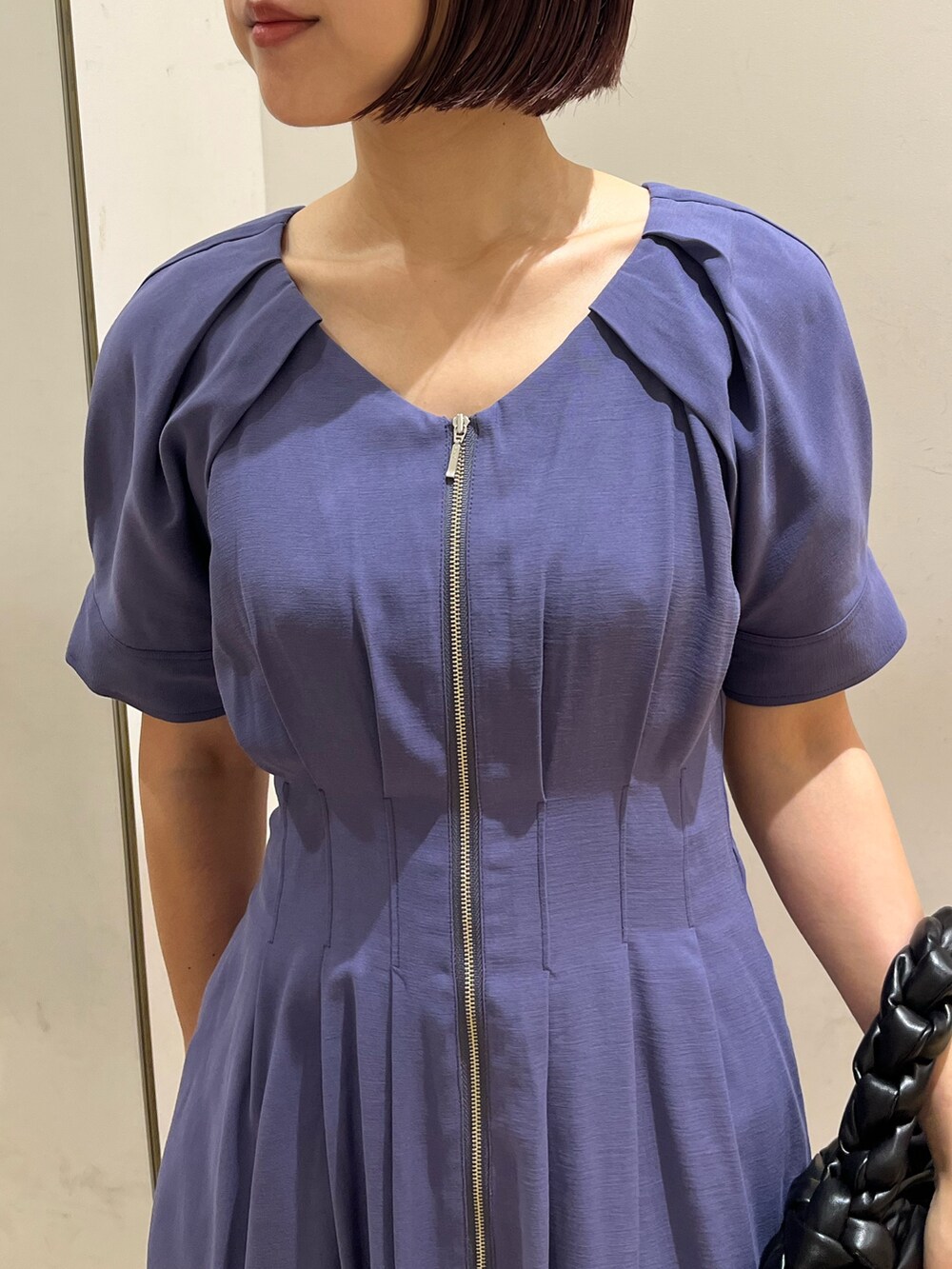 ブルー系のワンピース、ブラック系のハンドバッグ、ホワイト系のスニーカーを着用したレディースの夏コーディネートの4枚目の写真