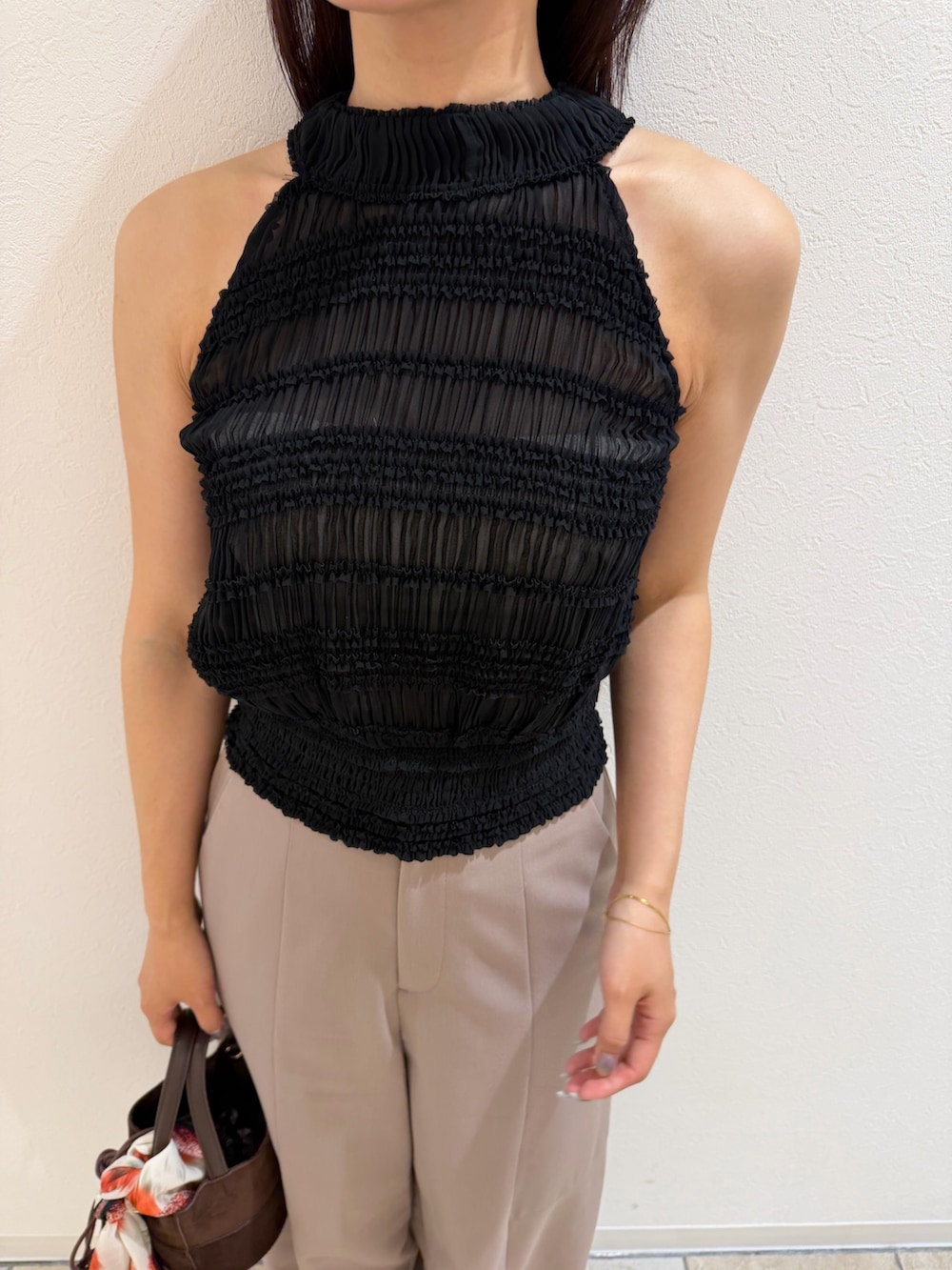 ブラウン系のハンドバッグ、ベージュ系のその他パンツ、ブラック系のシャツ/ブラウスを着用したレディースの夏コーディネートの6枚目の写真
