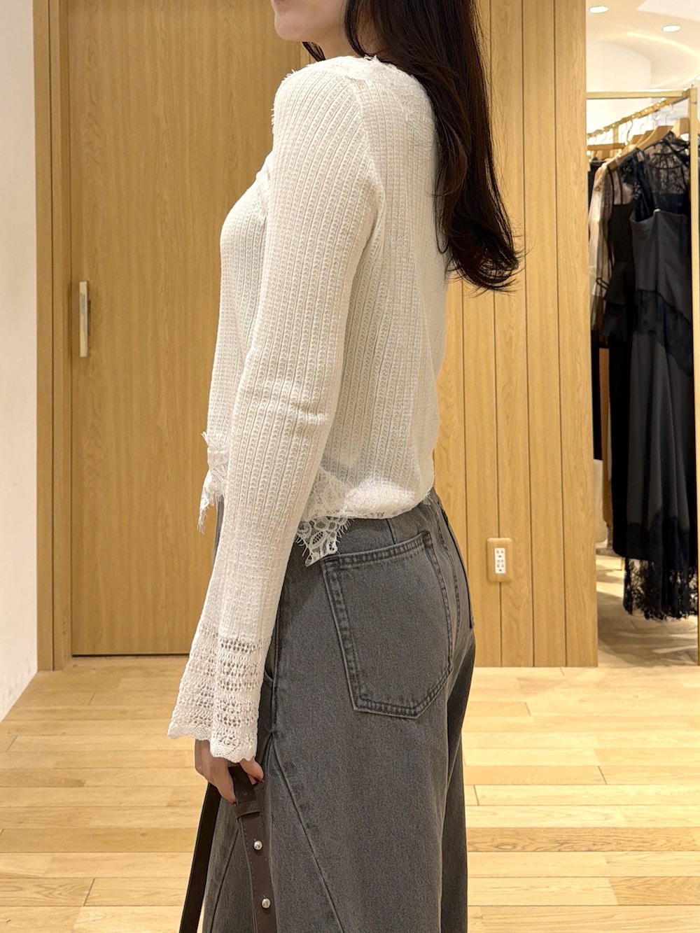 ホワイト系のカーディガン/ボレロ、グレー系のデニムパンツ、ブラウン系のハンドバッグを着用したレディースの秋コーディネートの6枚目の写真