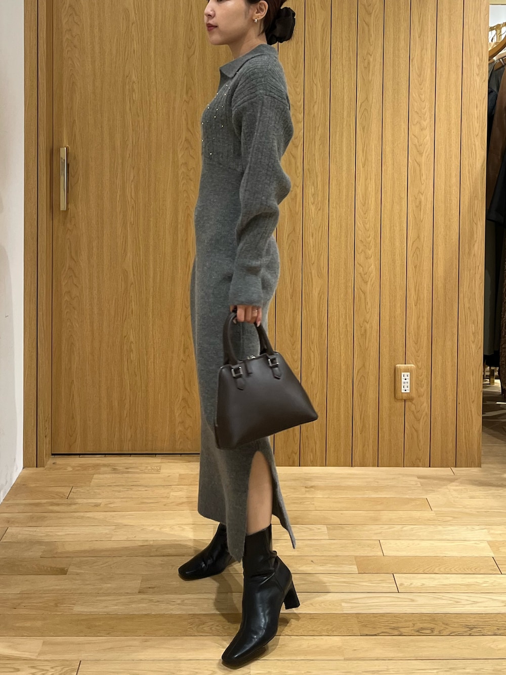 グレー系のワンピース、ホワイト系のダウンジャケット/コート、ブラウン系のボストンバッグを着用したレディースの秋コーディネートの7枚目の写真