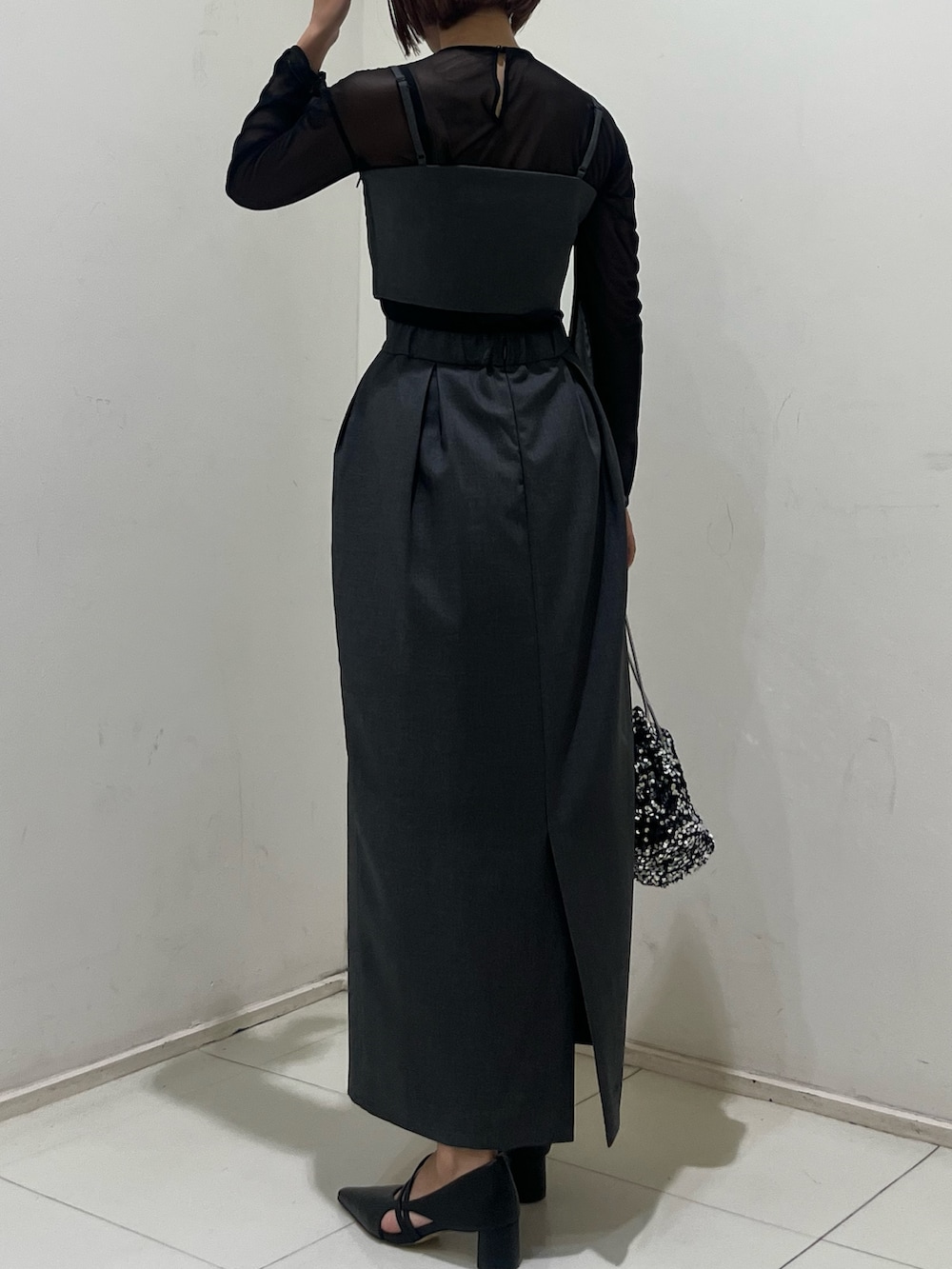 グレー系のドレス、ブラック系のパンプス、シルバー系のハンドバッグを着用したレディースの夏コーディネートの3枚目の写真