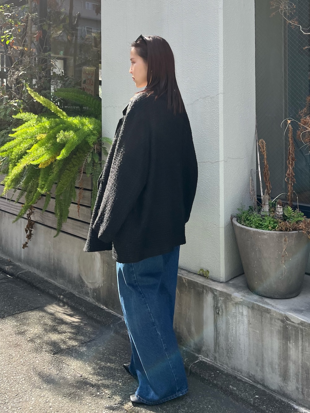 ホワイト系のニット/セーター、ブルー系のデニムパンツ、ブラック系のその他アウターを着用したレディースの冬コーディネートの4枚目の写真