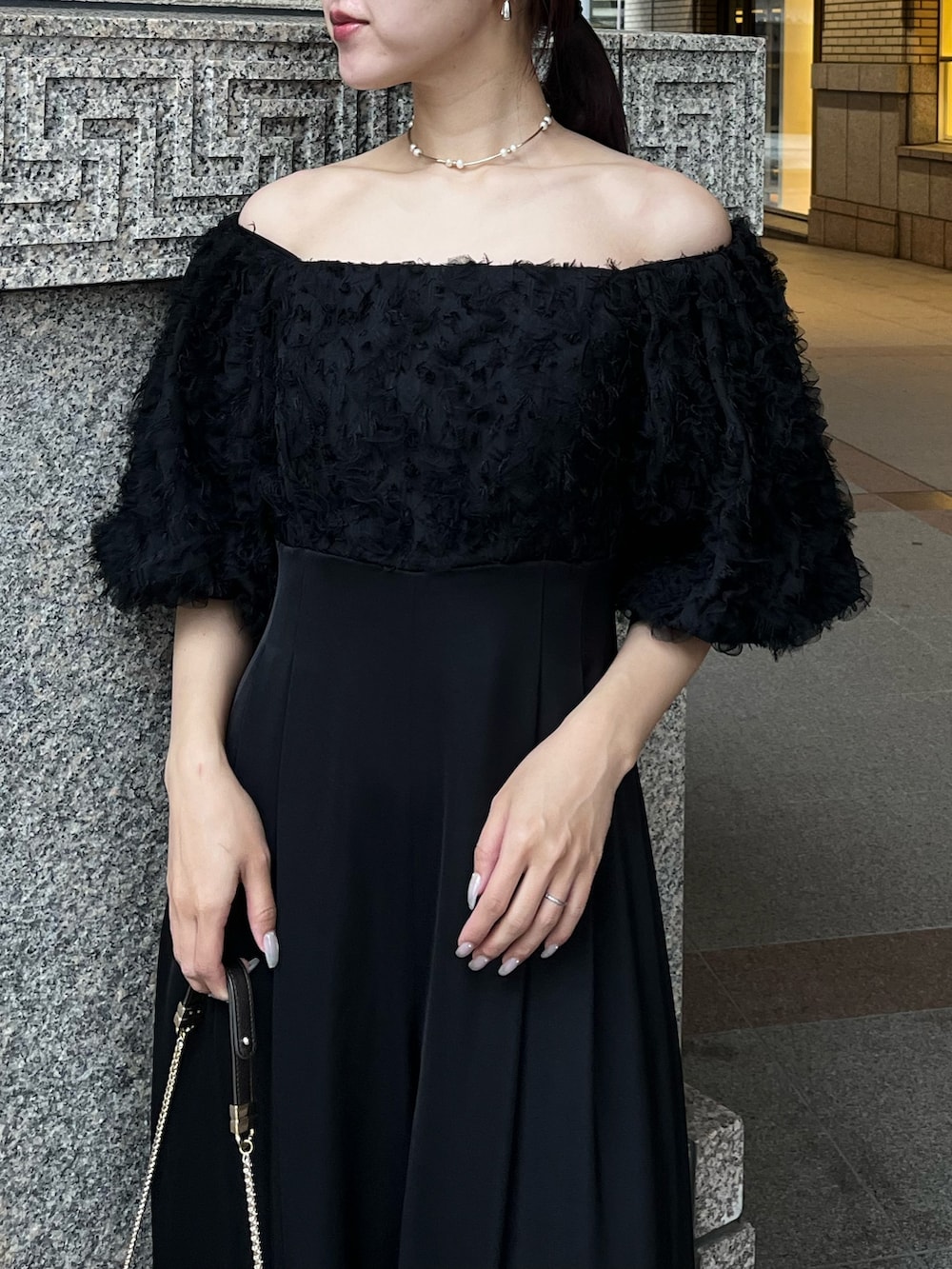 その他のパンプス、ブラック系のパンツドレス、その他のクラッチバッグを着用したレディースの冬コーディネートの8枚目の写真