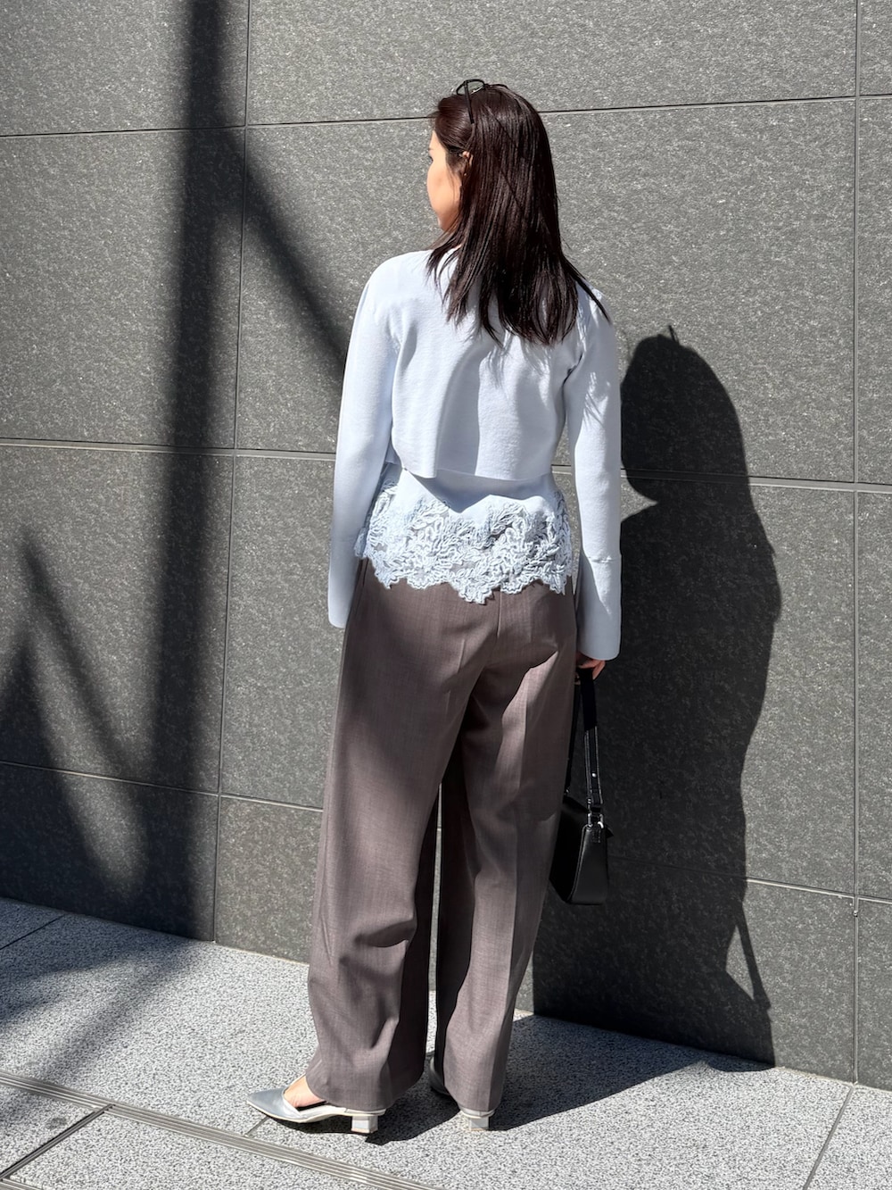 ブルー系のトレンチコート、グレー系のその他パンツ、ブラック系のハンドバッグを着用したレディースの冬コーディネートの8枚目の写真