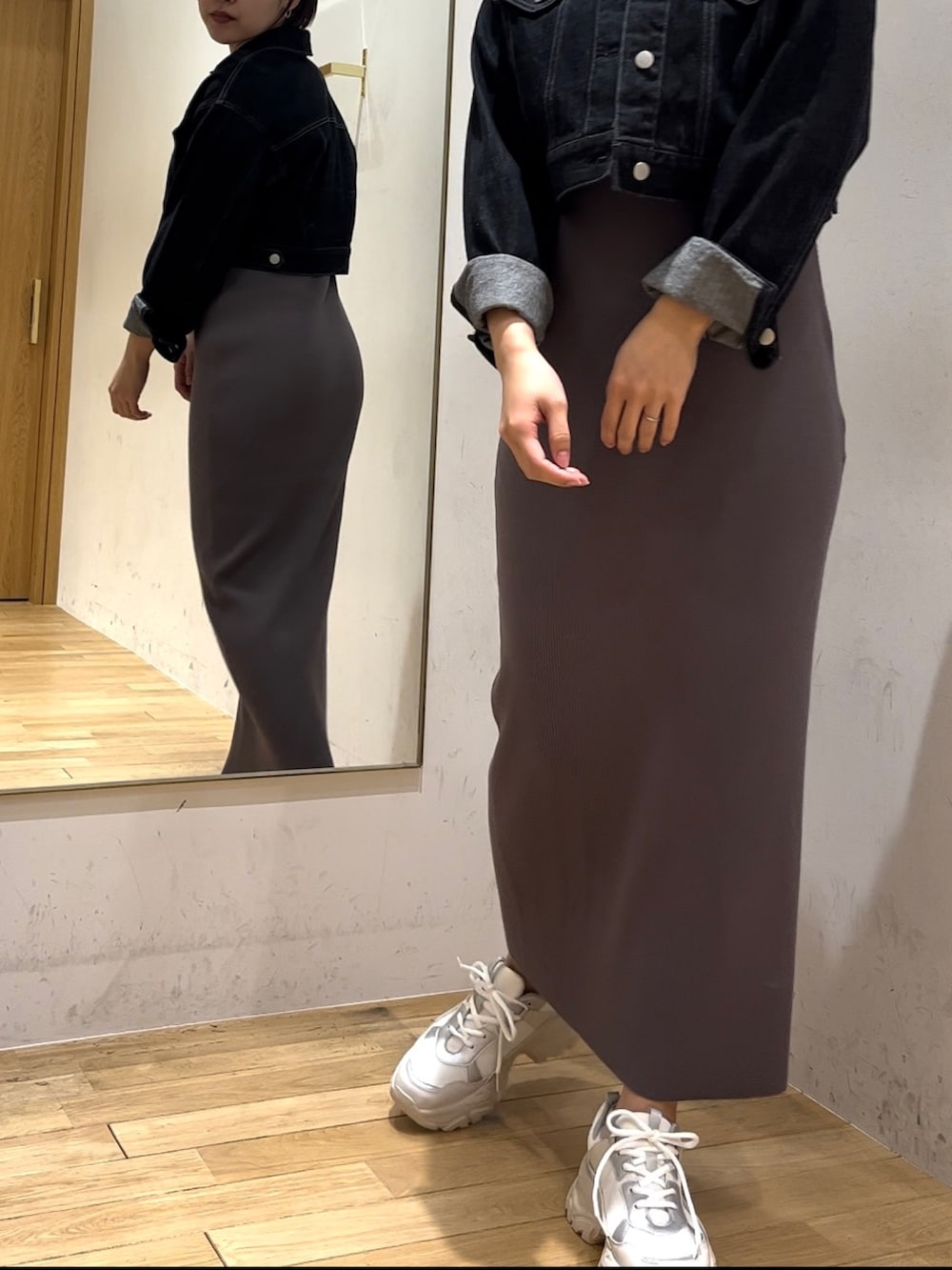 ブラック系のデニムジャケット、グレー系のワンピースを着用したレディースの冬コーディネートの4枚目の写真