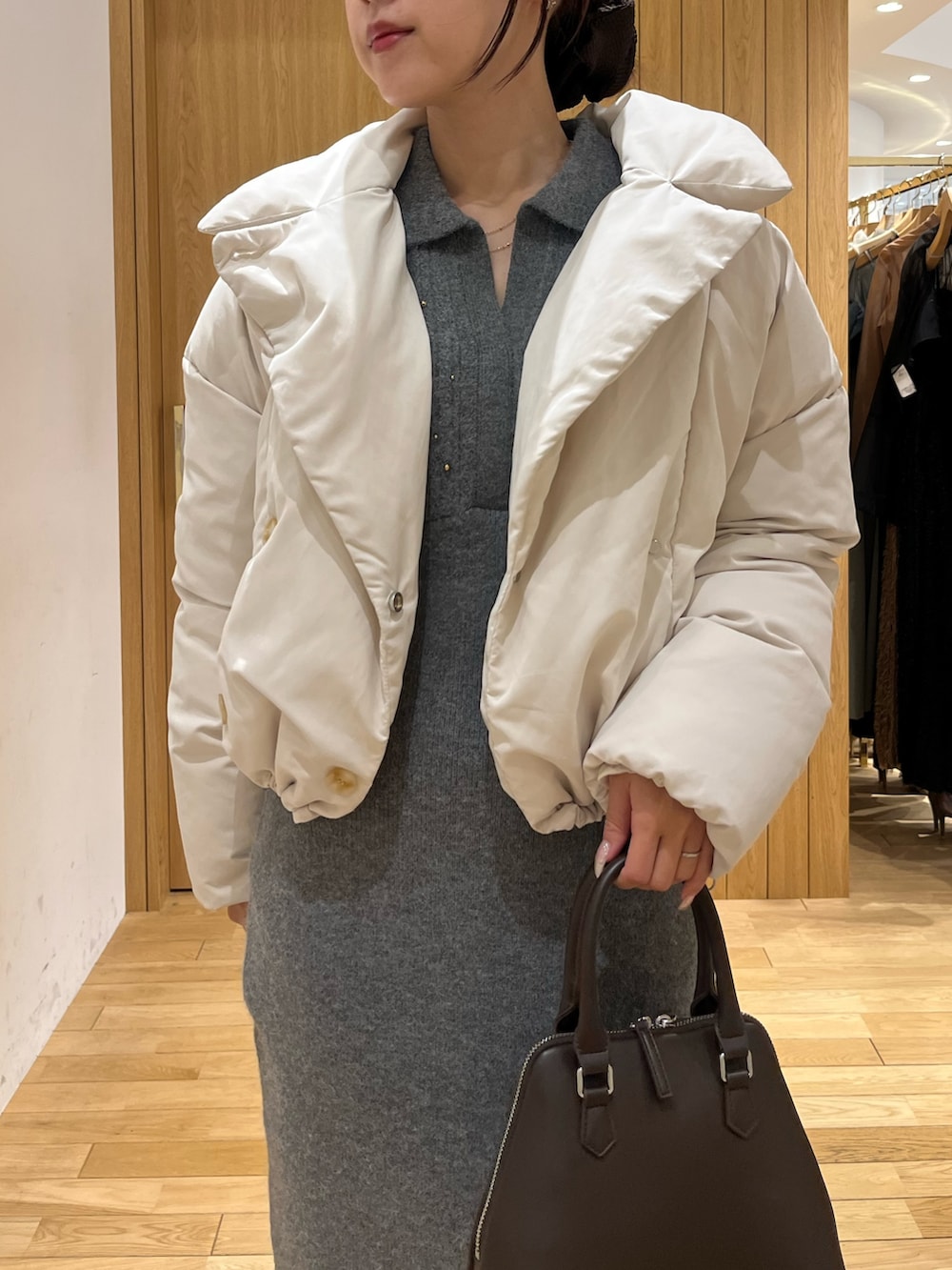 グレー系のワンピース、ホワイト系のダウンジャケット/コート、ブラウン系のボストンバッグを着用したレディースの秋コーディネートの4枚目の写真