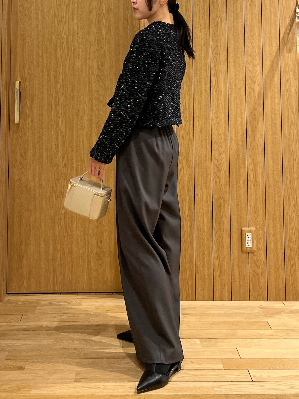 グレー系のその他パンツ、ブルー系のカーディガン/ボレロ、ゴールド系のハンドバッグを着用したレディースの冬コーディネートの2枚目の写真