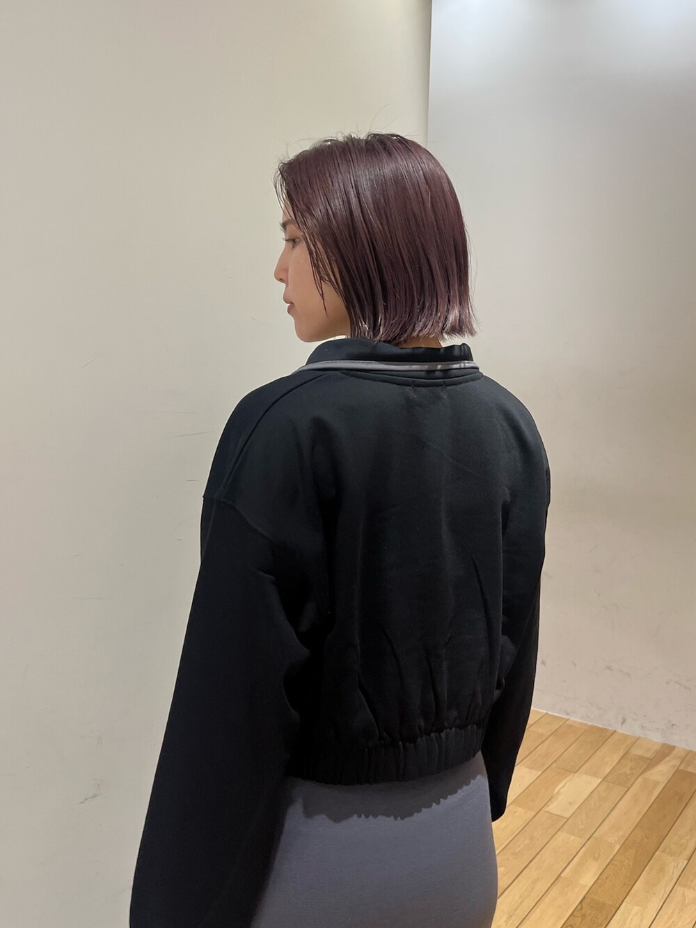 グレー系のスカート、ブラック系のスウェット、シルバー系のブーツを着用したレディースの秋コーディネートの5枚目の写真