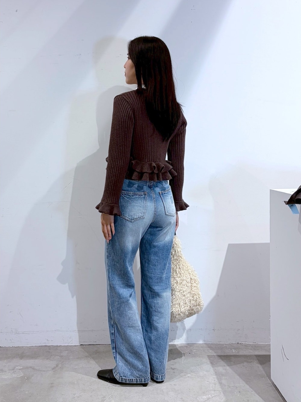 ブラウン系のニット/セーター、ブルー系のデニムパンツ、ブラック系のブーツを着用したレディースの夏コーディネートの3枚目の写真
