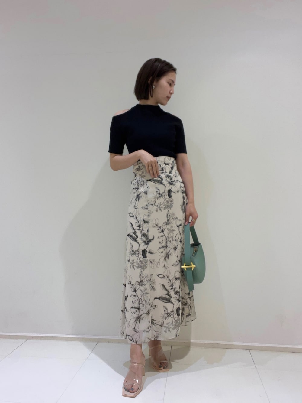 ベージュ系のテーラードジャケット、グリーン系のハンドバッグ、その他のサンダルを着用したレディースの春コーディネートの2枚目の写真