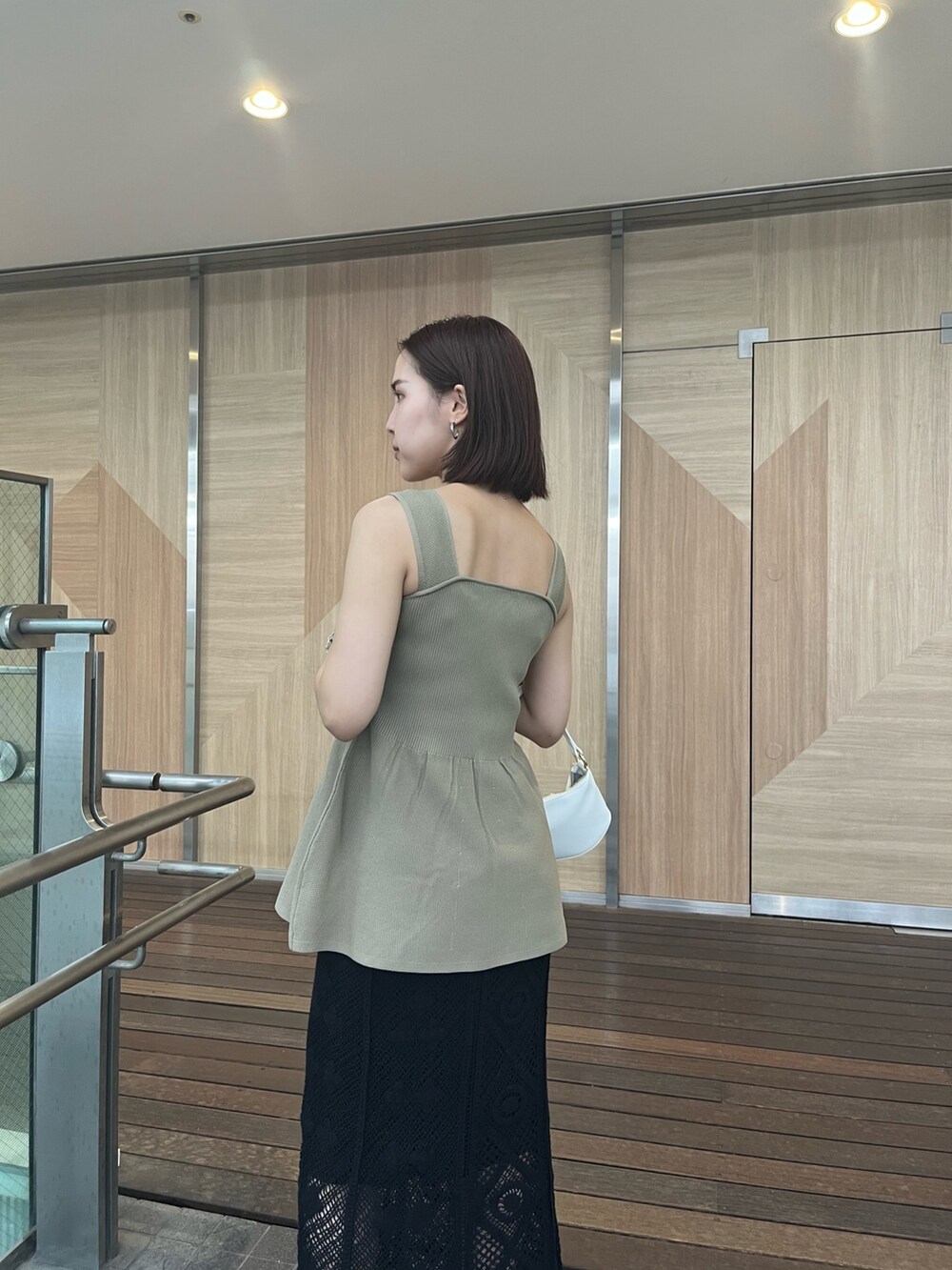 ベージュ系のニット/セーター、ブラック系のスカート、その他のサンダルを着用したレディースの夏コーディネートの3枚目の写真