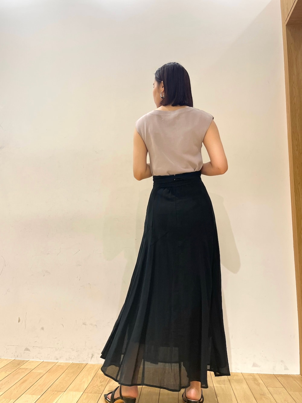 パープル系のニット/セーター、ブラック系のサンダル、ブラック系のスカートを着用したレディースの夏コーディネートの3枚目の写真