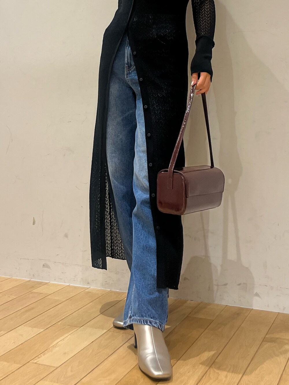 ブラック系のワンピース、レッド系のショルダーバッグ、シルバー系のブーツを着用したレディースの秋コーディネートの5枚目の写真